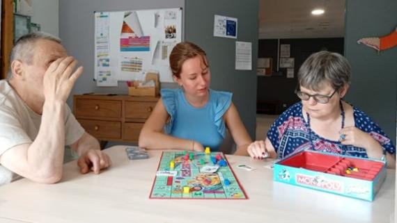 Sina Westenfelder beim Gesellschaftsspiel mit zwei Bewohnern.