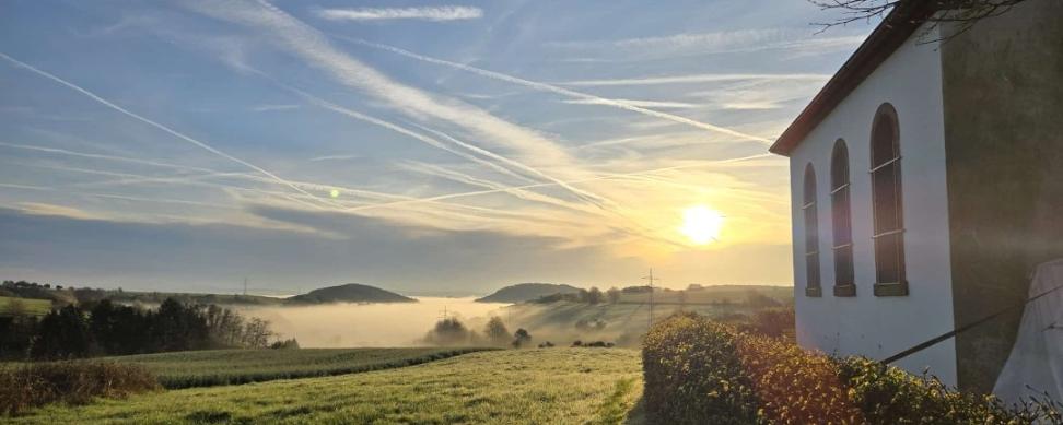 Hinter der  Urwahlener Kapelle  geht die Sonne auf