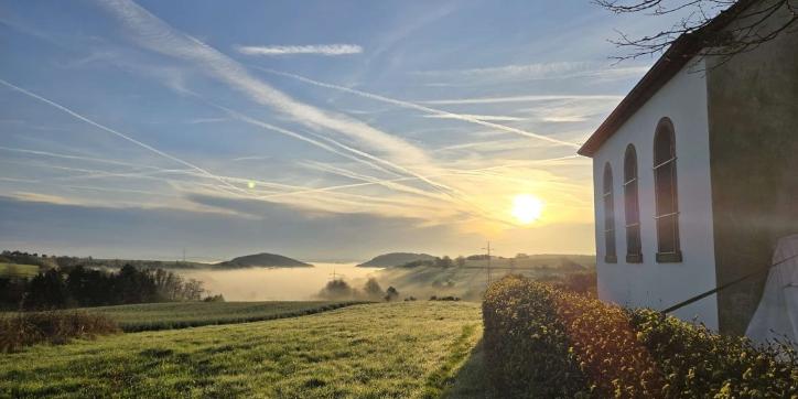 Hinter der  Urwahlener Kapelle  geht die Sonne auf