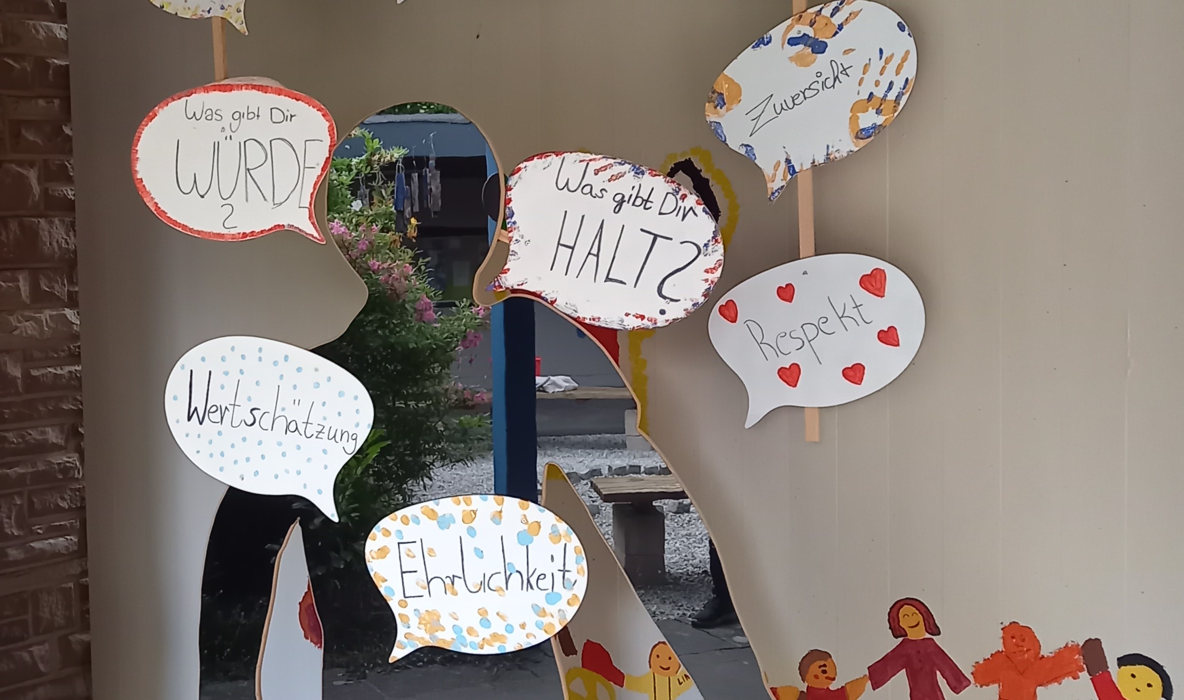 Im Atrium der Jugendkirche Mia steht eine Pappfigur mit vielen Sprechblasen zum Thema Haltung