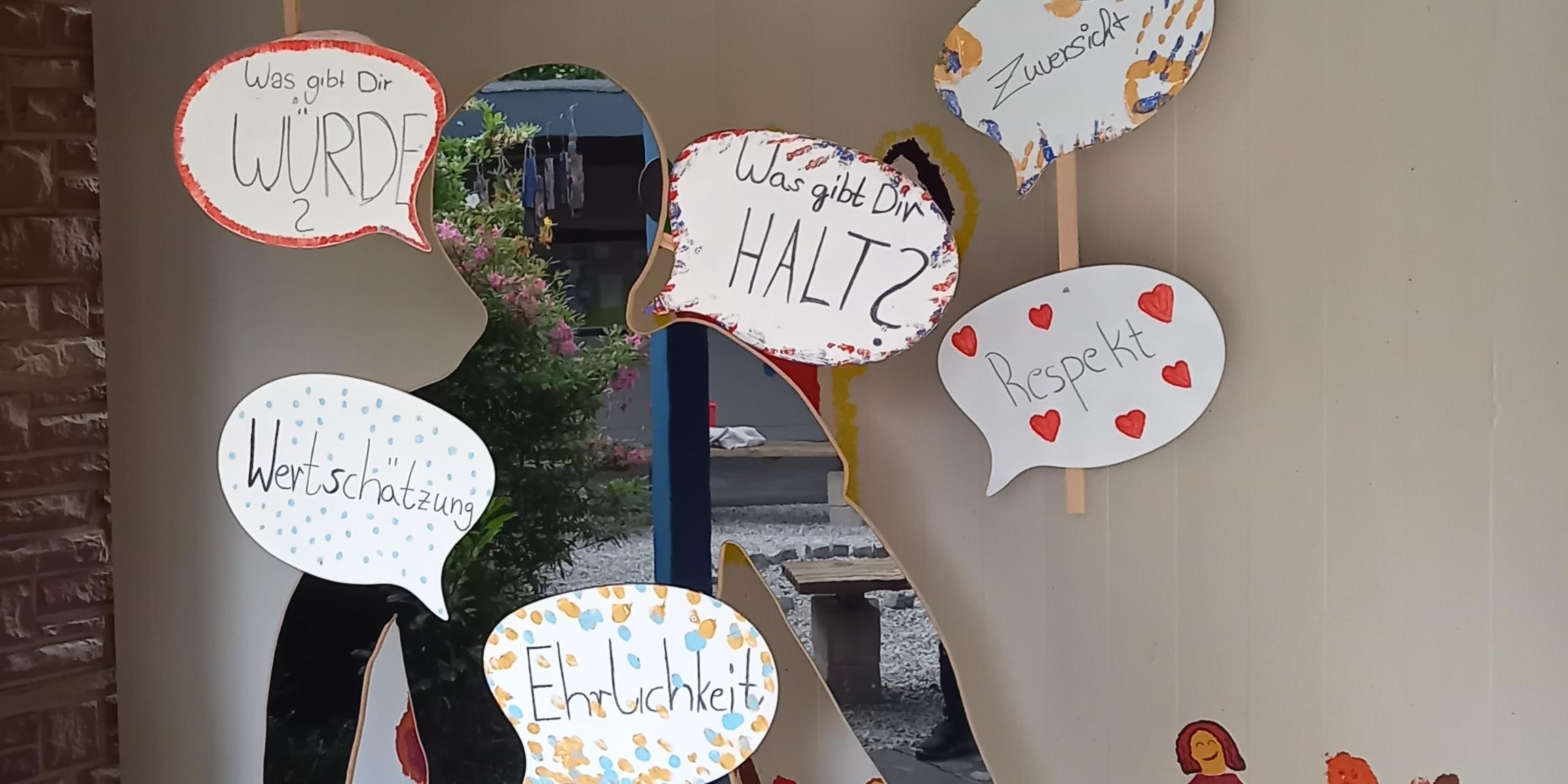 Im Atrium der Jugendkirche Mia steht eine Pappfigur mit vielen Sprechblasen zum Thema Haltung