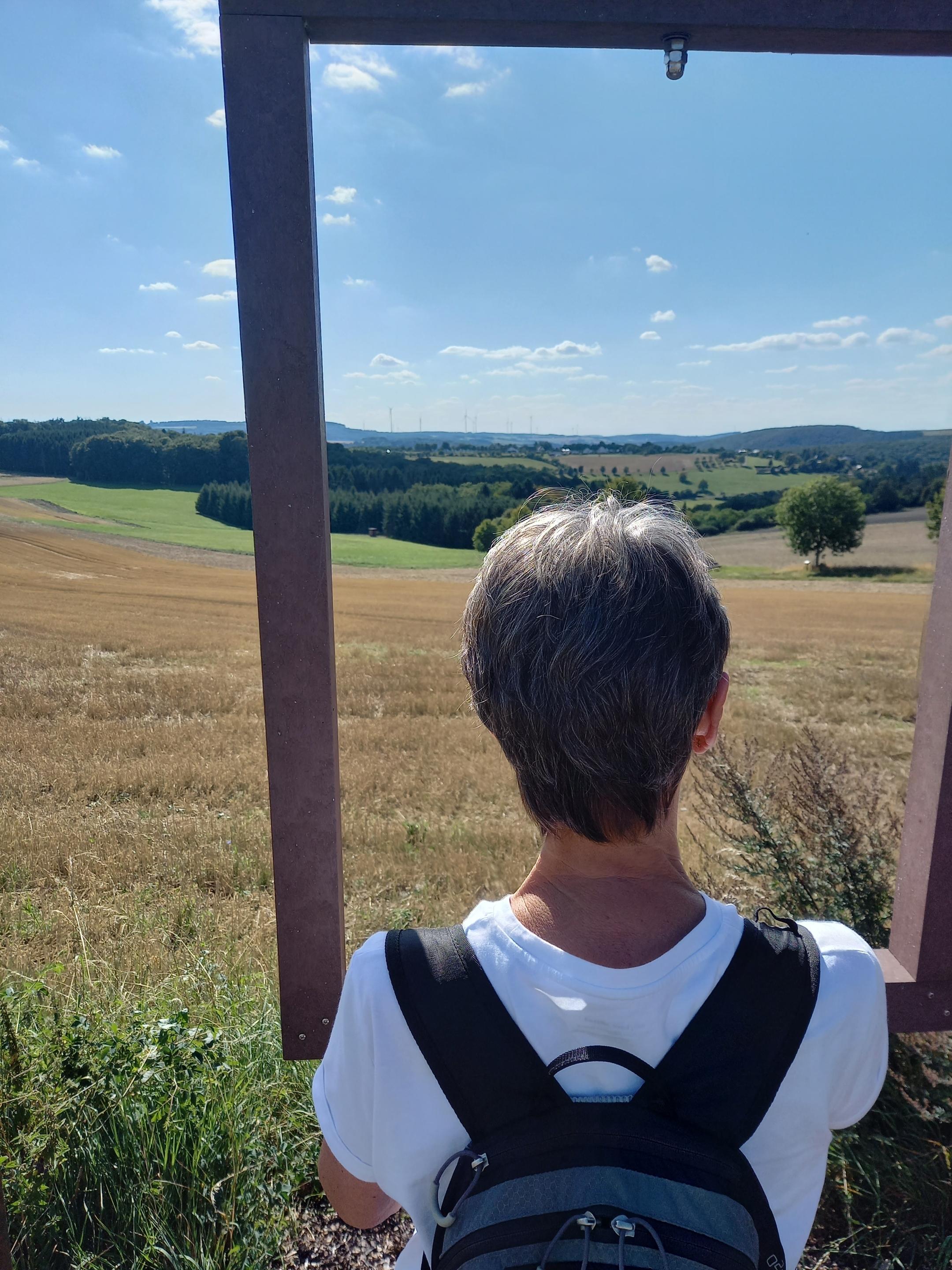Eine Frau steht vor einer Durchsicht vor Wiesen und Bäumen (c) Rainer Stuhlträger Eine Frau steht vor einer Durchsicht vor Wiesen und Bäumen
