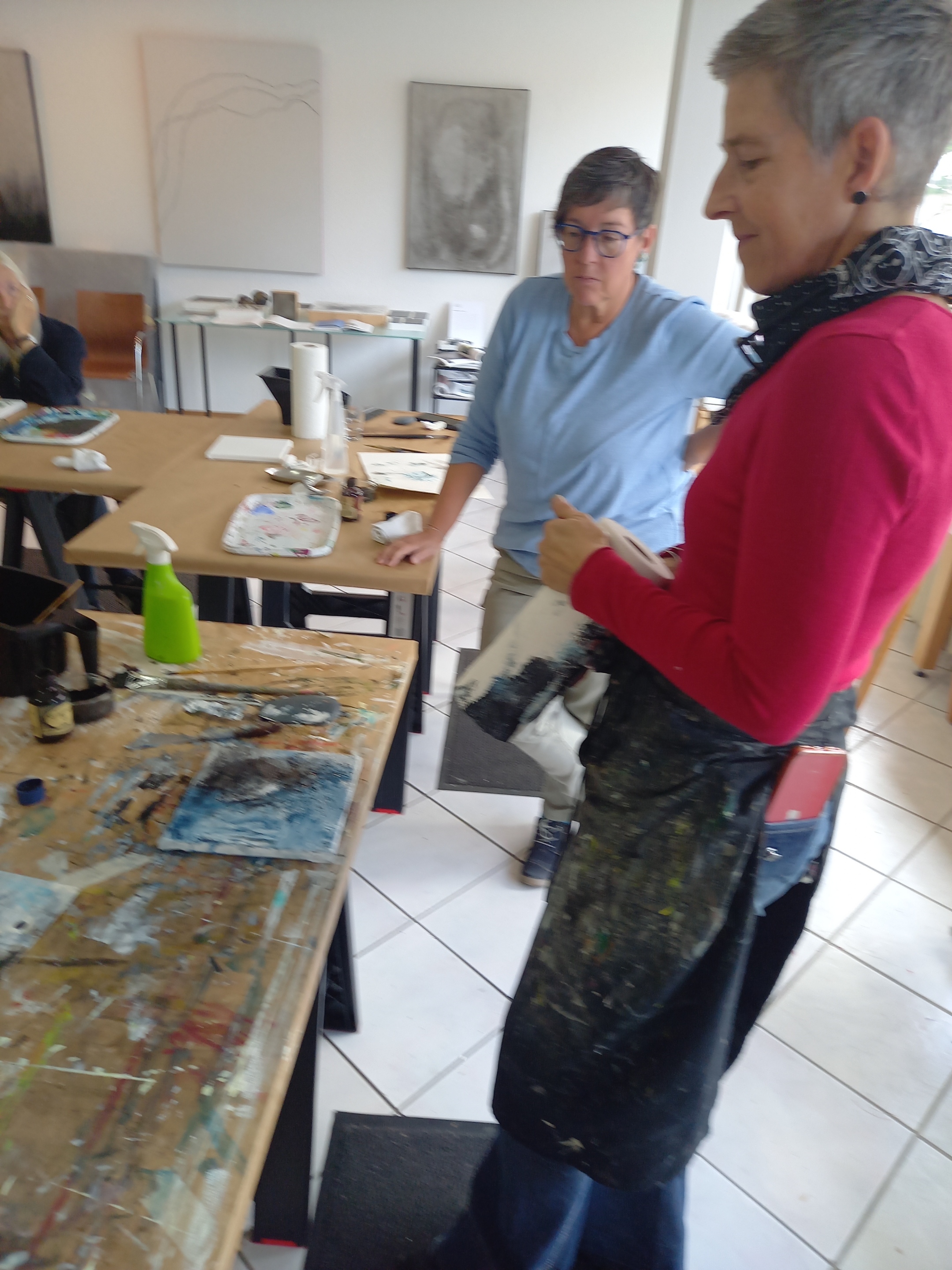 Die Künstlerin zeigt an einem Bild eine mögliche Arbeitsweise (c) Rainer Die Künstlerin , Bettina Reichert, zeigt an einem Bild ihre Arbeitsweise