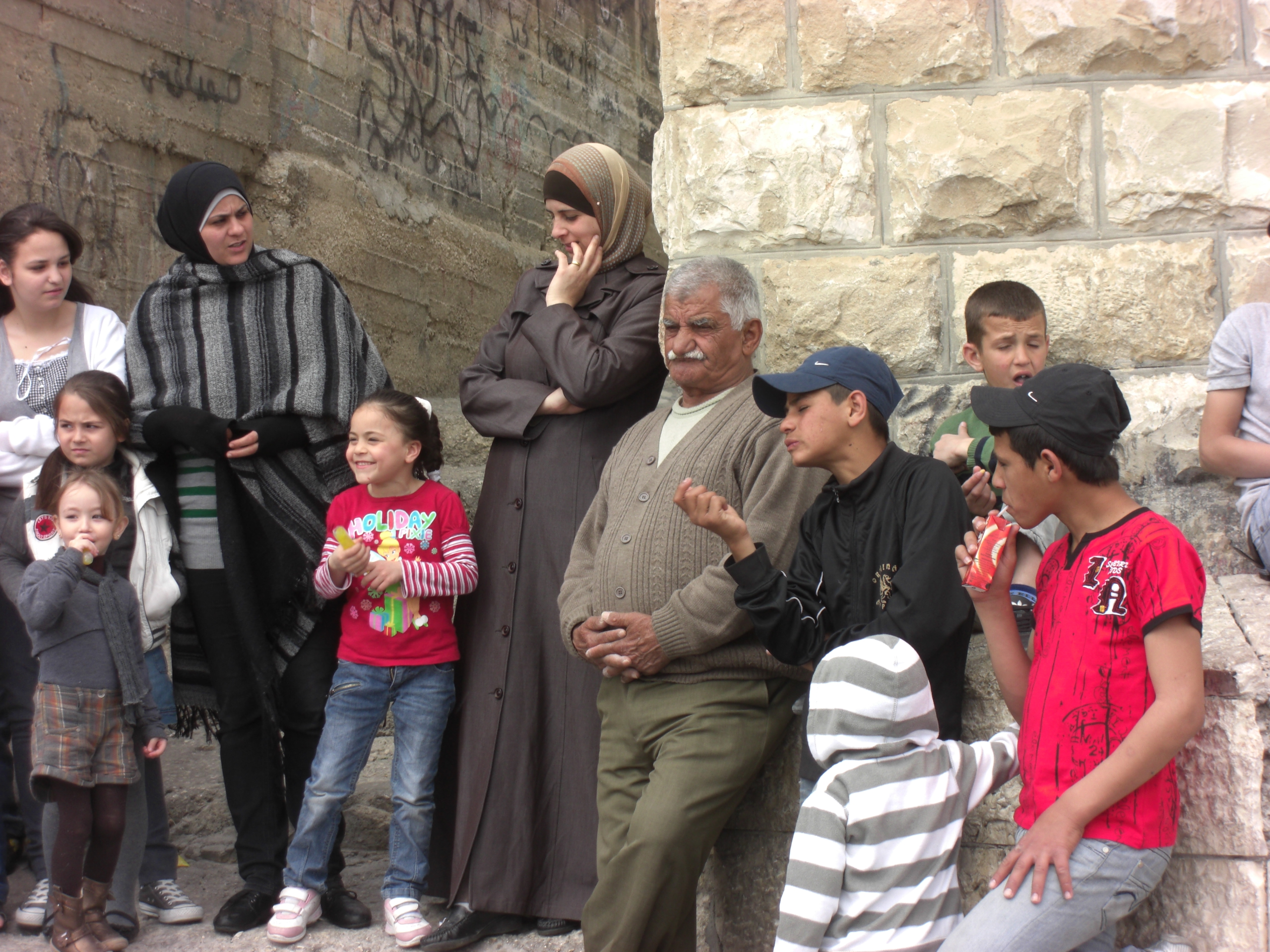 Menschen in Jerusalem stehen an einer Wand und beobachten
