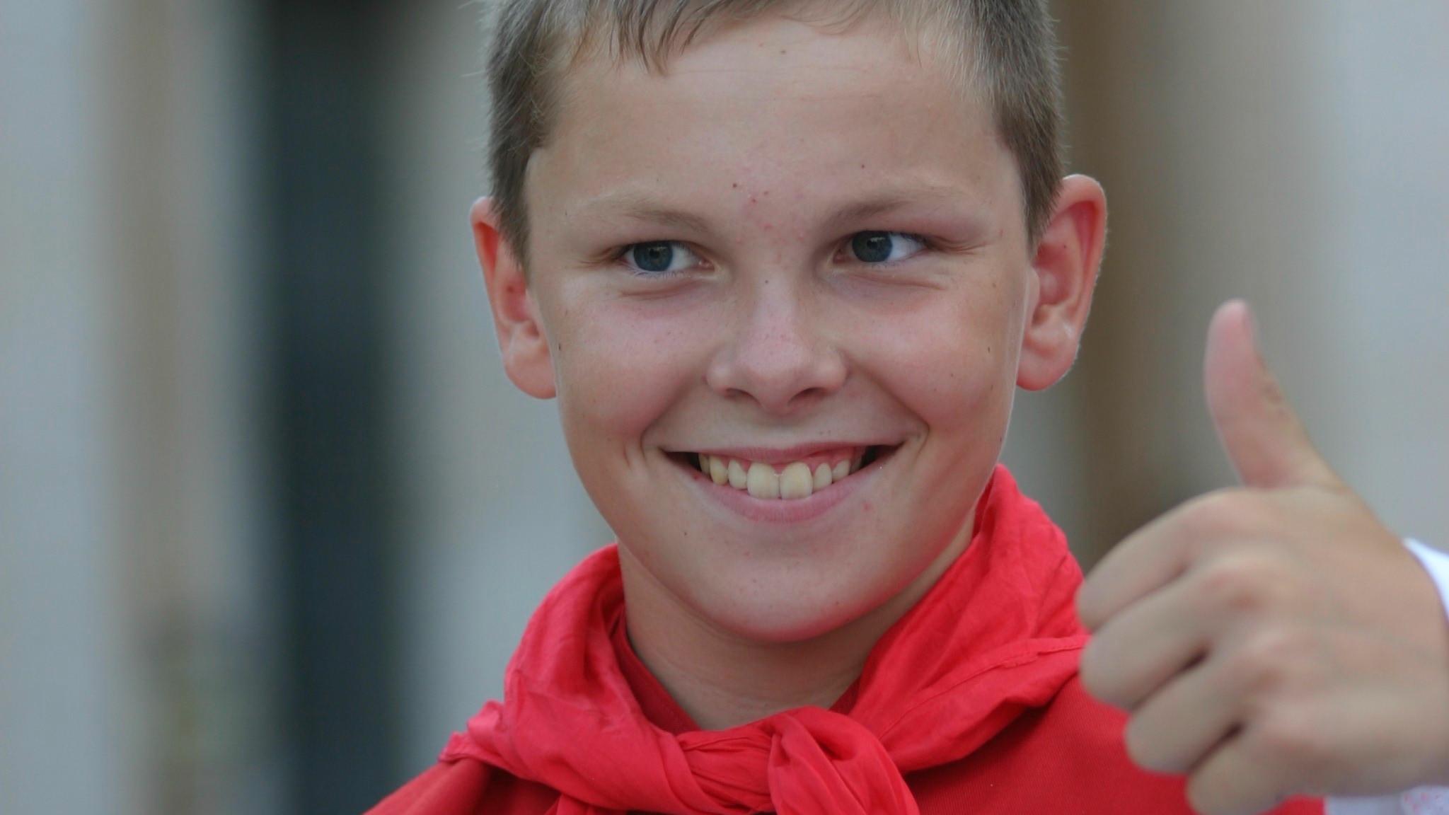 Ein Messdiener zeigt lachen einen Daumen nach oben