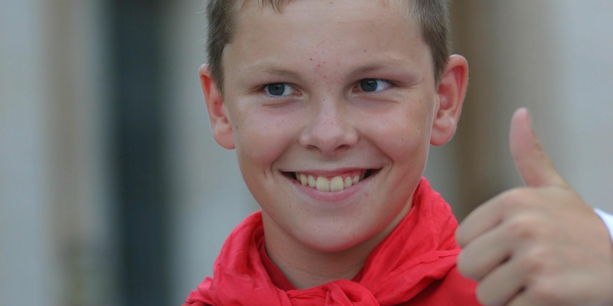 Ein Messdiener zeigt lachen einen Daumen nach oben