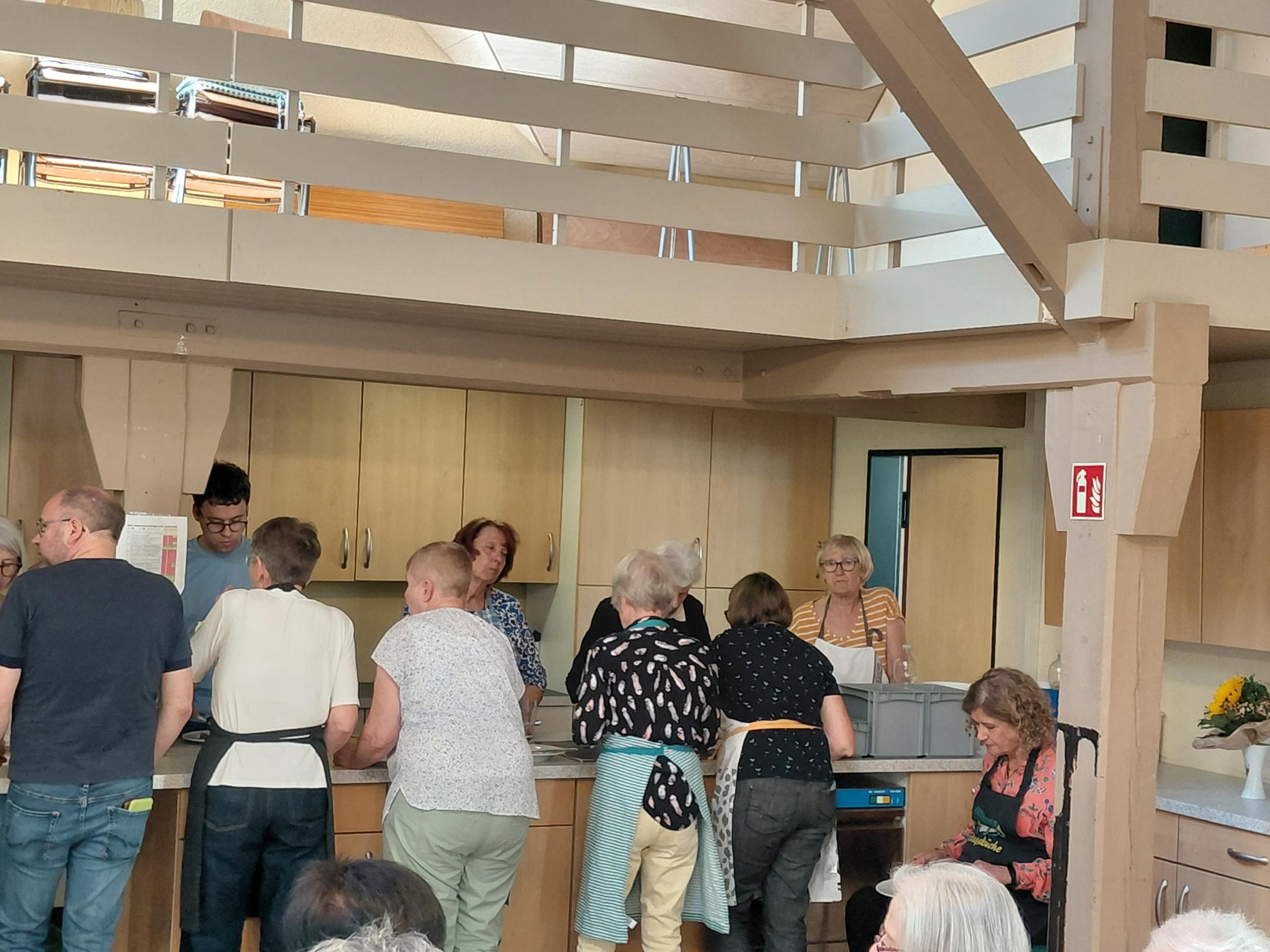 Das Team steht am neuen Buffet im Pfarrheim (c) Anne Schommer Einige Personen stehen in Schütze an einem Tresen