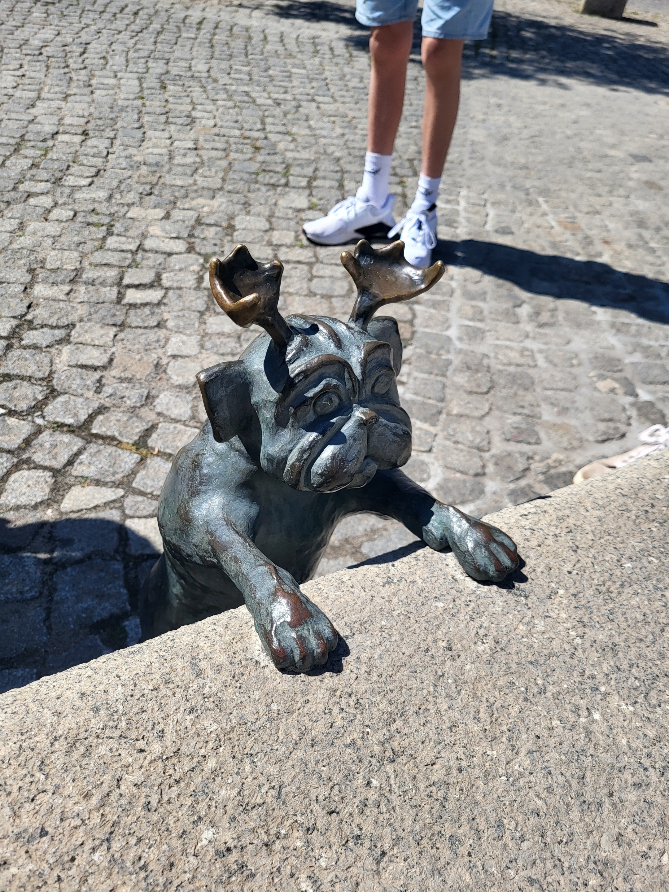 Ein steinerner Hund mit Geweih als Skulptur