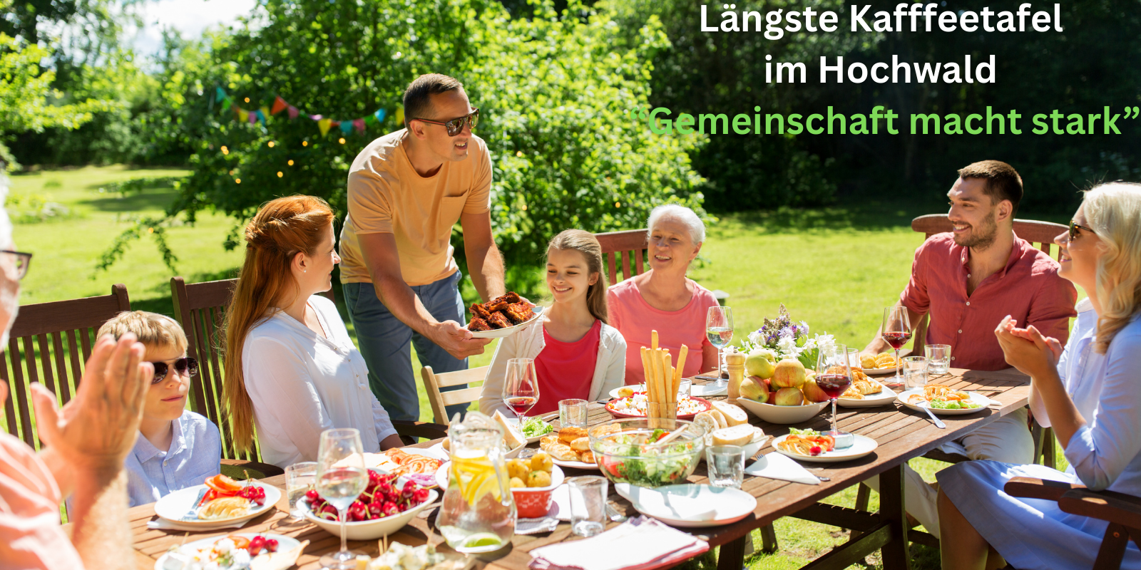 Familie am Kaffeetisch mit Aufschrift 'Längste Kaffeetafel im Hochwald Gemeinschaft macht stark'