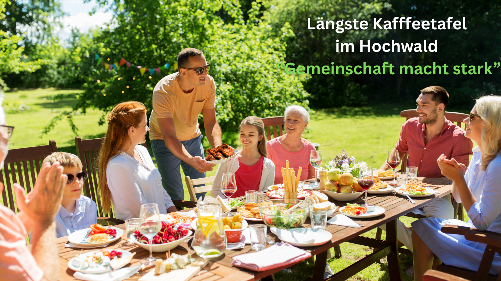 Familie am Kaffeetisch mit Aufschrift 'Längste Kaffeetafel im Hochwald Gemeinschaft macht stark'