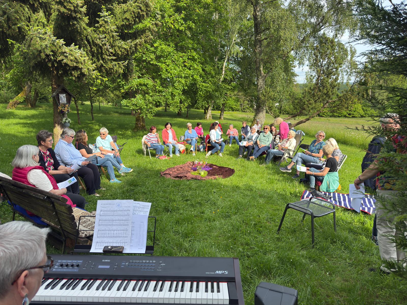 Frauen versammelt zu einem Gottesdienst auf einer Wiese