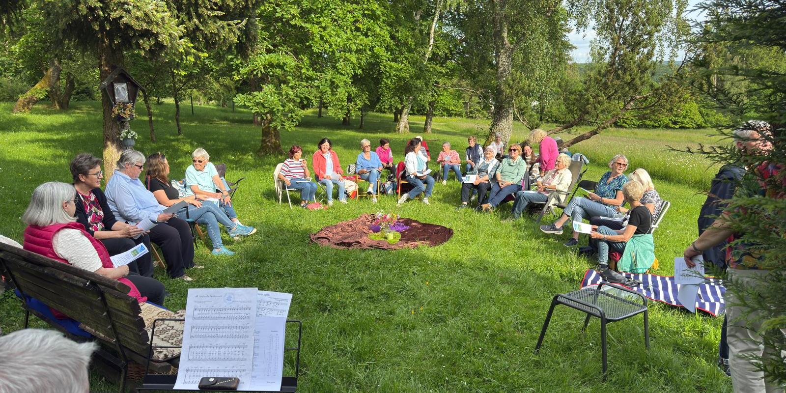 Frauen versammelt zu einem Gottesdienst auf einer Wiese