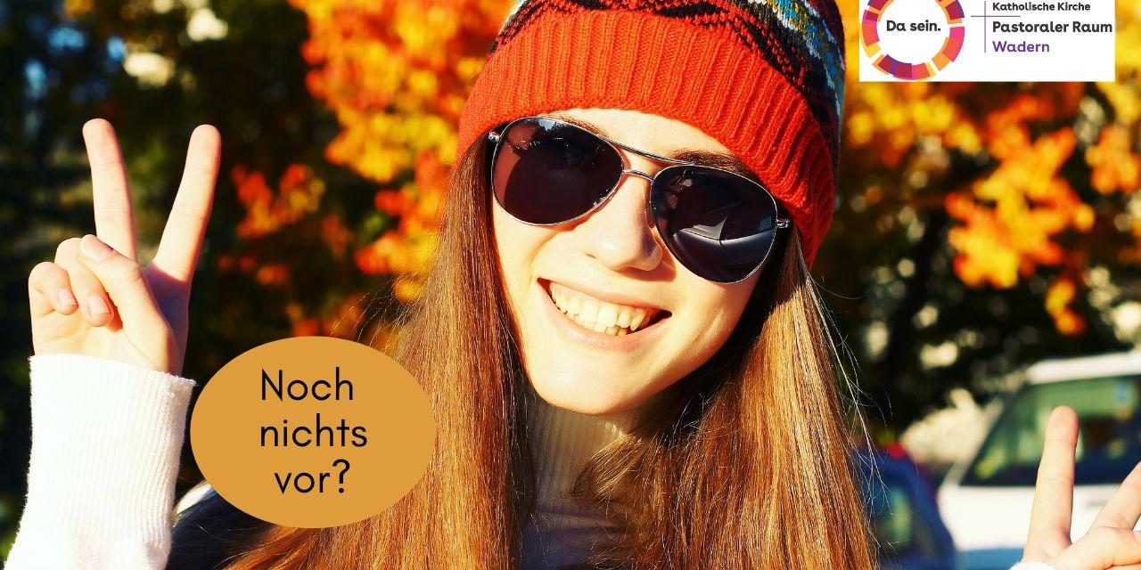 Eine Jugendliche mit Sonnenbrille lacht und macht ein Victory - Zeichen. Eine Aufschrift fragte: Noch nichts vor?