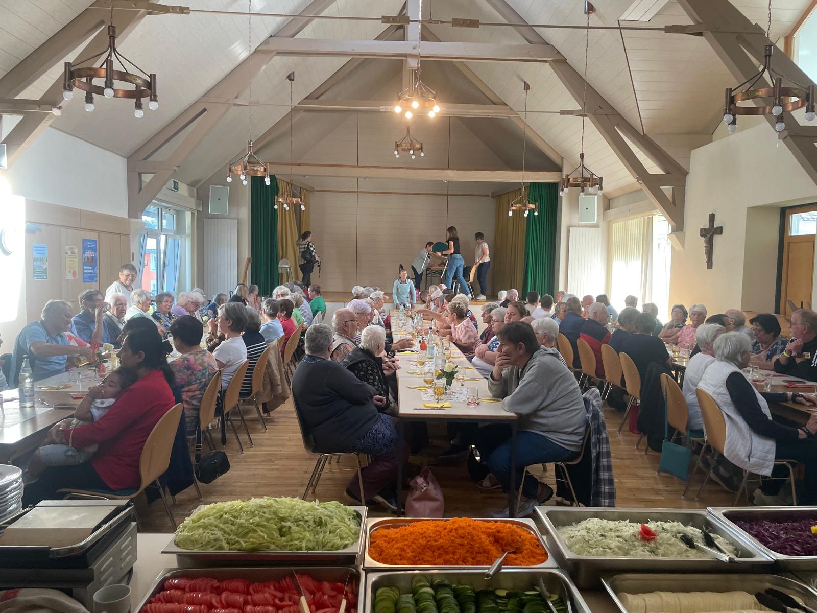 Im Waderner Pfarrheim sitzen die Menschen essen und trinken