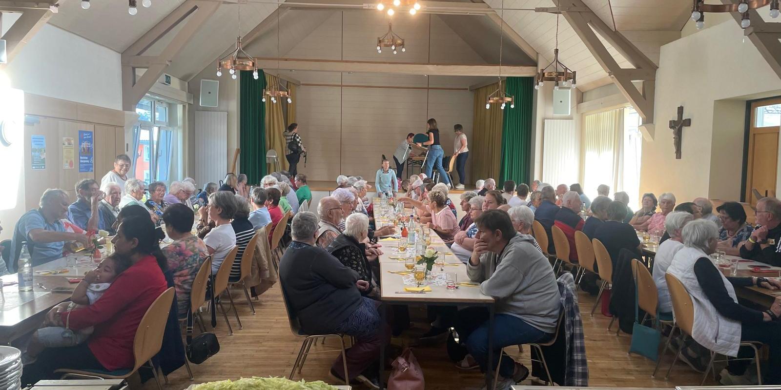 Im Waderner Pfarrheim sitzen die Menschen essen und trinken
