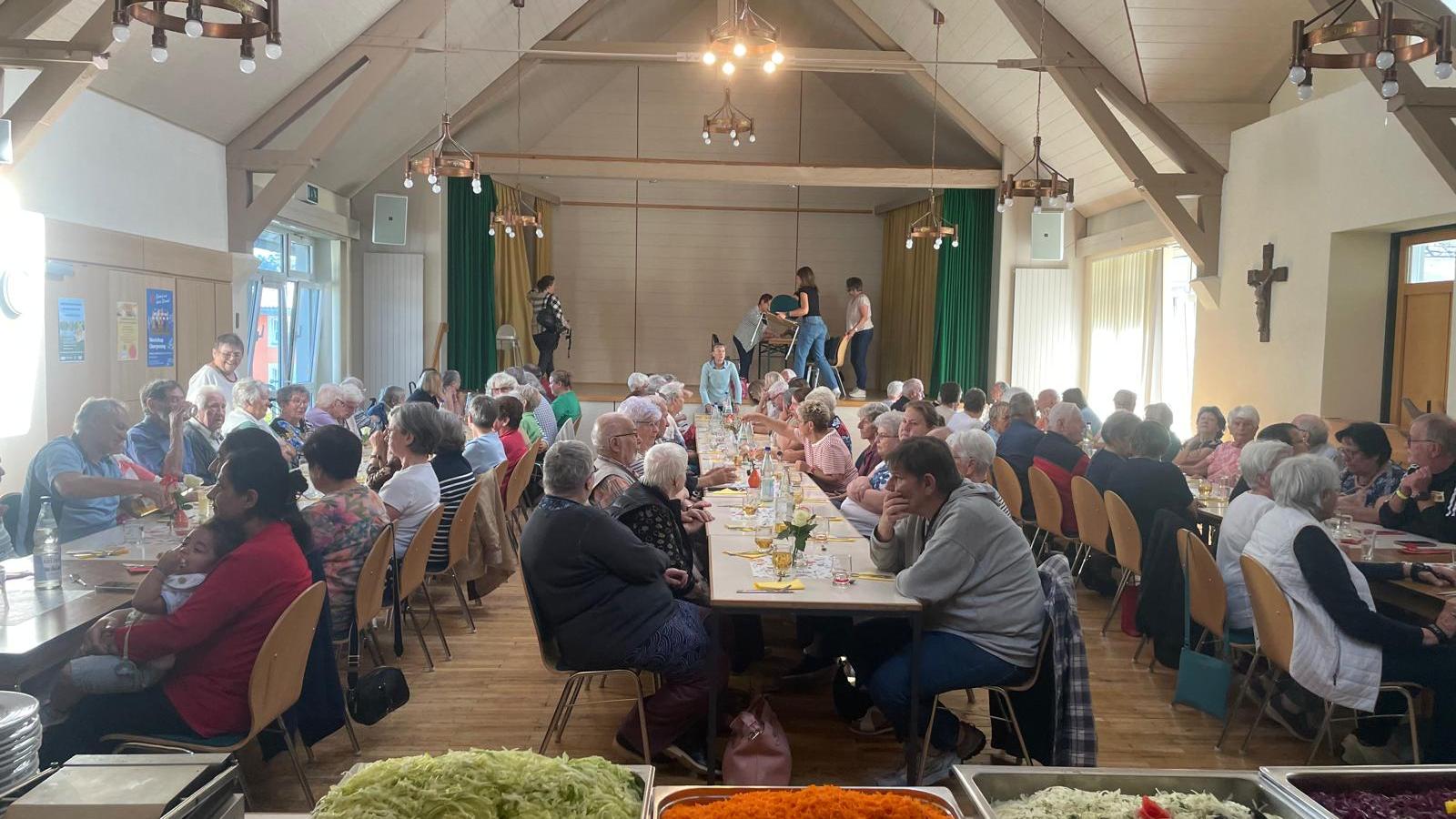 Im Waderner Pfarrheim sitzen die Menschen essen und trinken