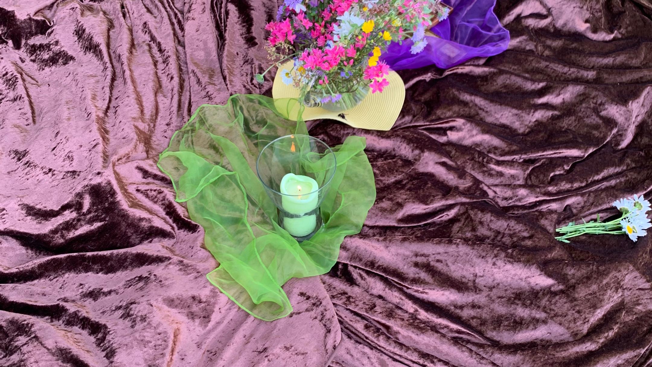 Eine Decke mit Kerze und Blumen