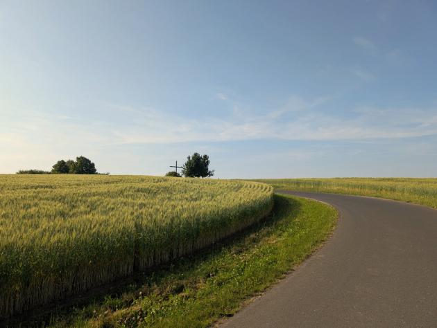 Ein Weg führt durch Felder zu einer Kapelle