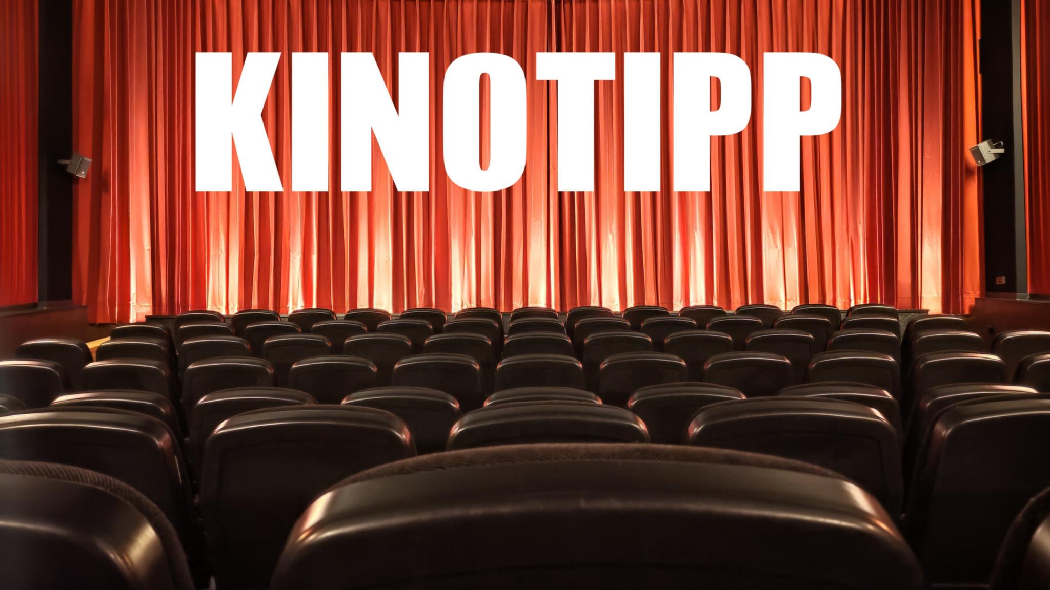 Kinosaal mit leeren Reihen, geschlossenem Vorhang und Aufschrift KINOTIPP