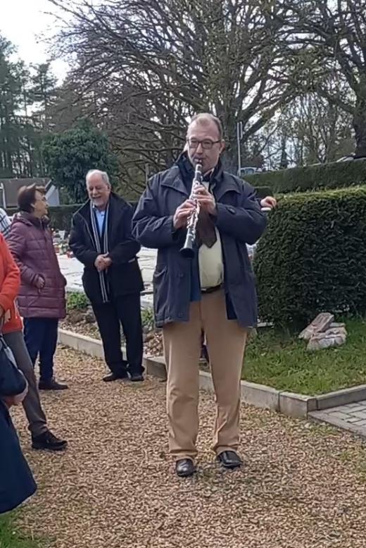 Eine Musiker mit Klarinette spielt auf einem Friedhof