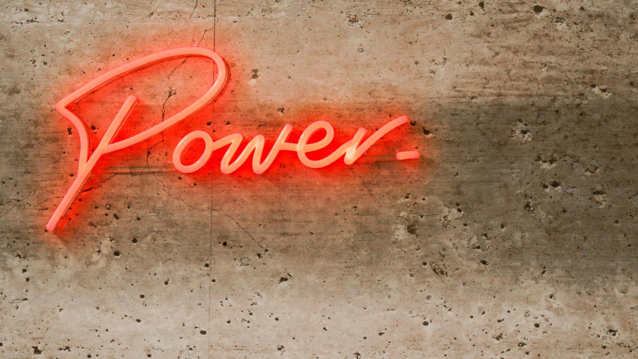 Ein Schriftzug in Leuchtbuchtstaben an der Wand:POWER