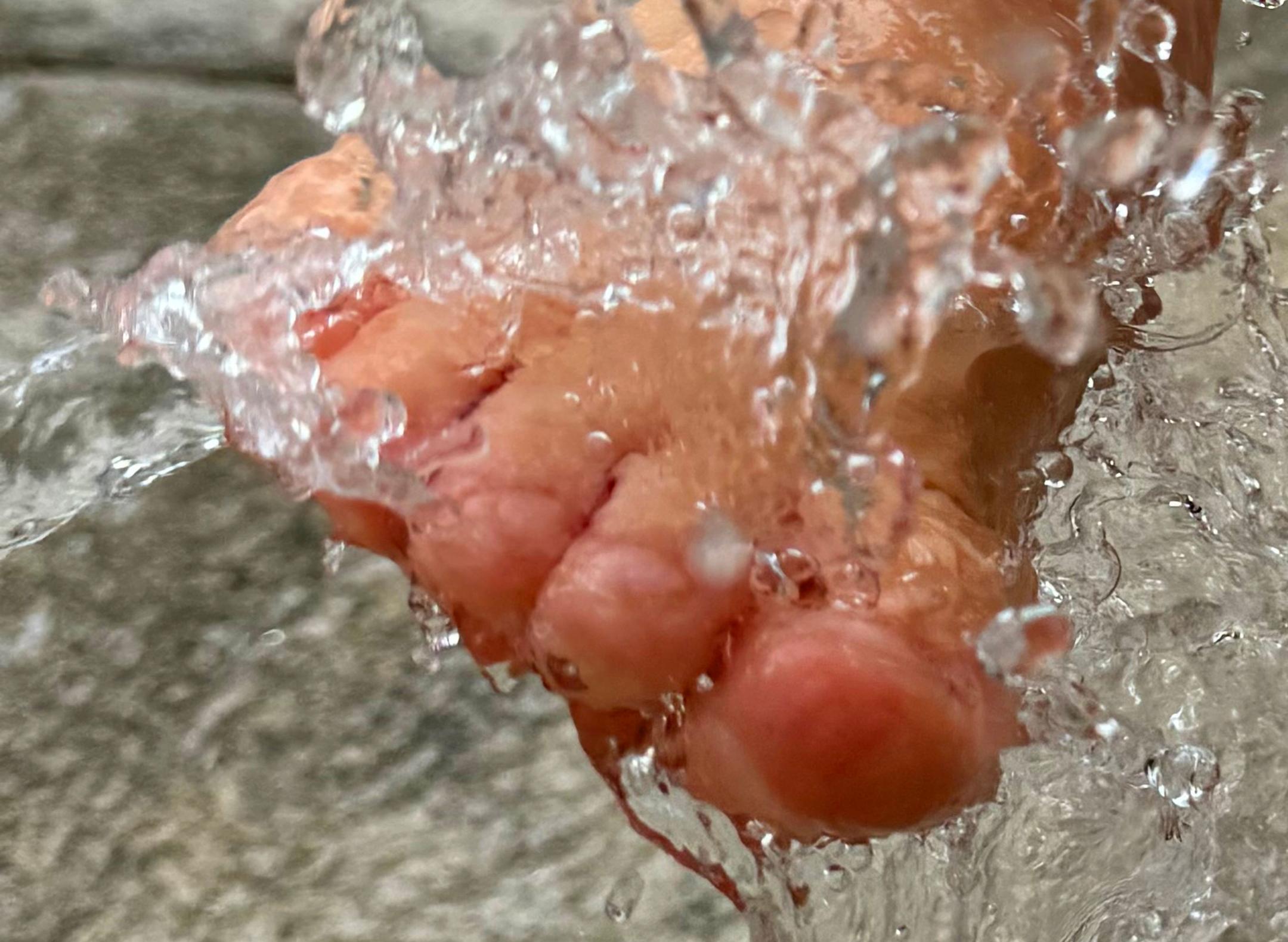 Ein Fuß wird im Brunnen erfrischt