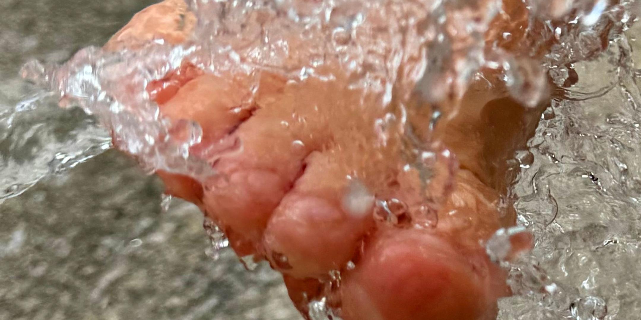 Ein Fuß wird im Brunnen erfrischt