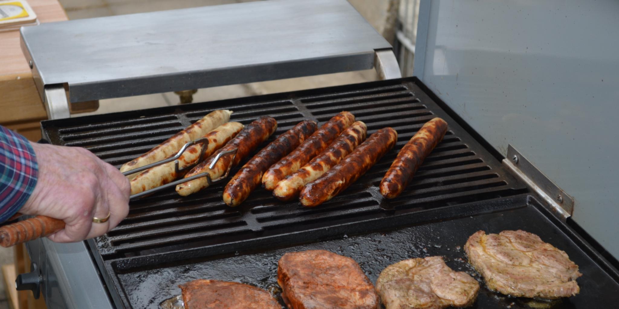 Auf dem Grill finden sich Würste und Schwenker
