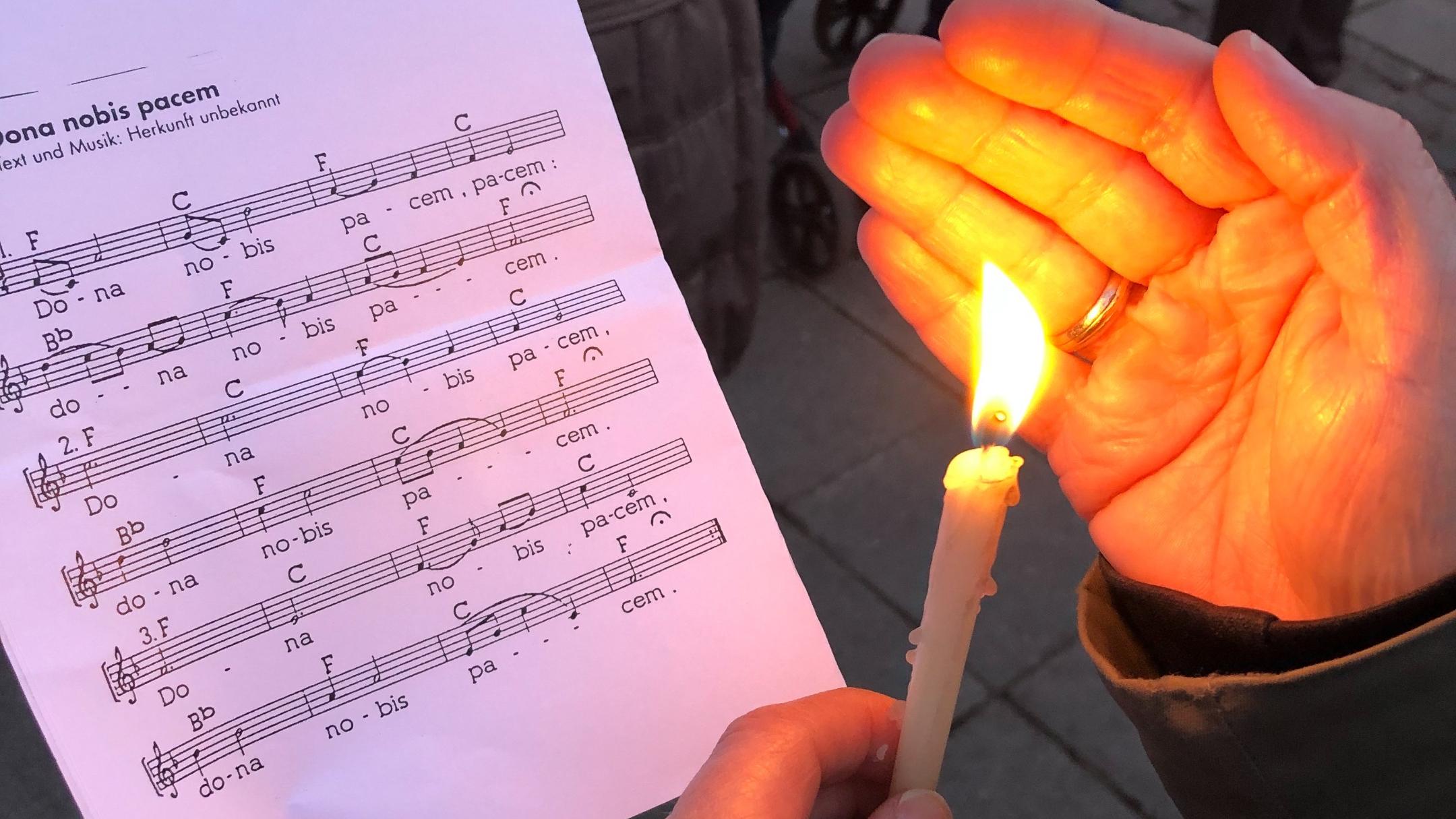Eine Kerze scheint auf ein Liedblatt