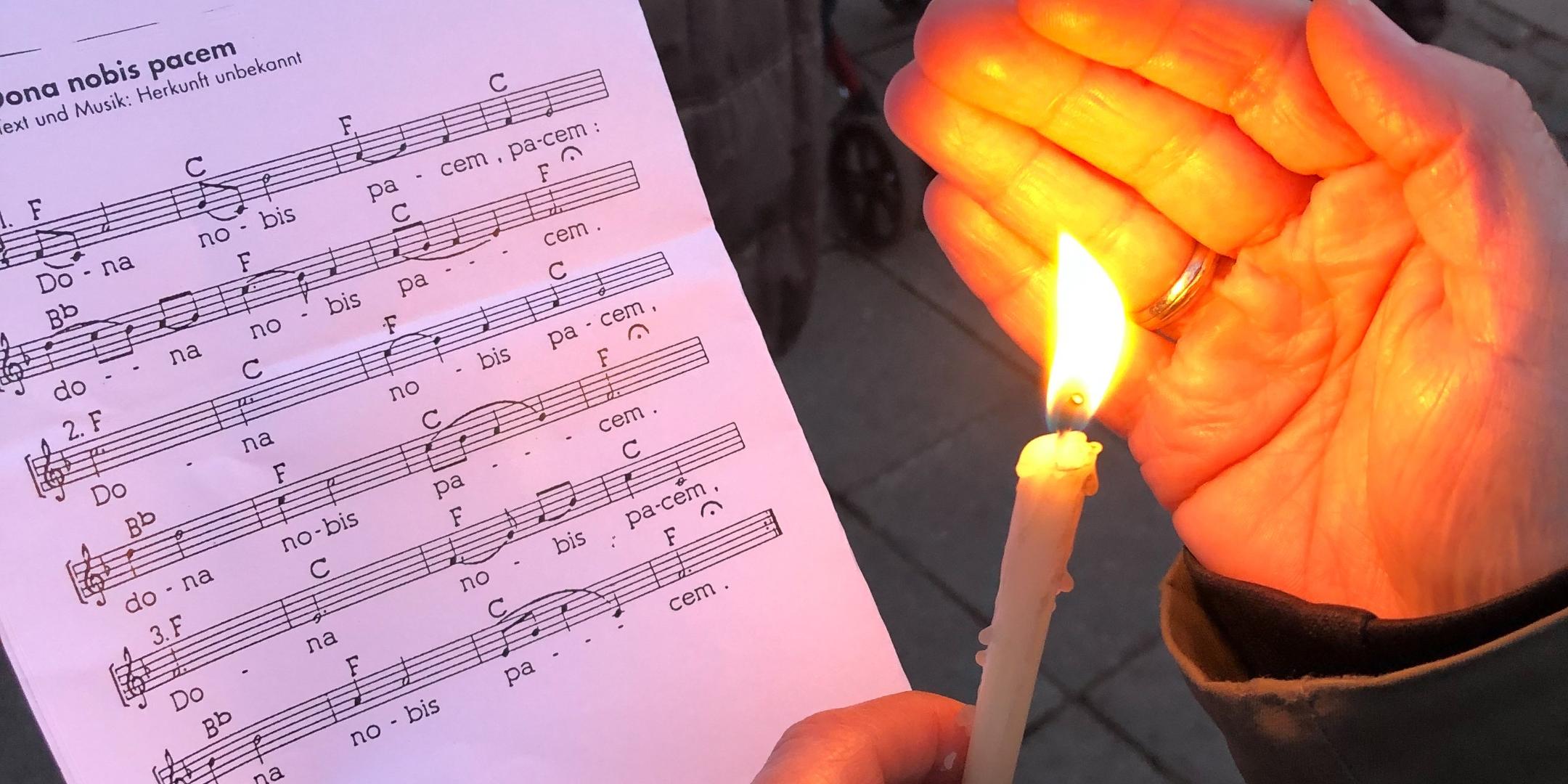 Eine Kerze scheint auf ein Liedblatt