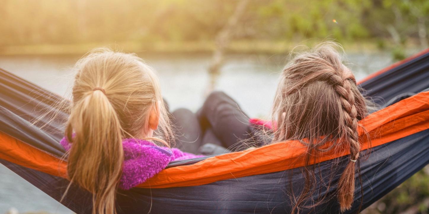 Zwei Mädchen sitzen nebeneinander in der Hängematte