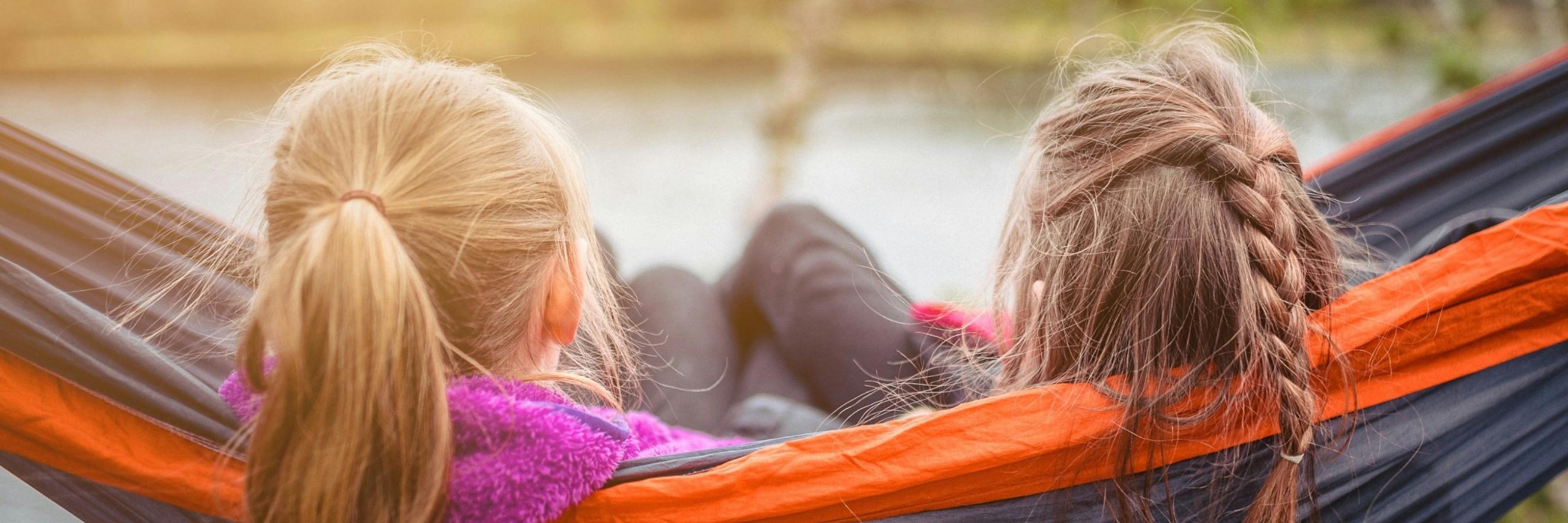 Zwei Mädchen sitzen nebeneinander in der Hängematte