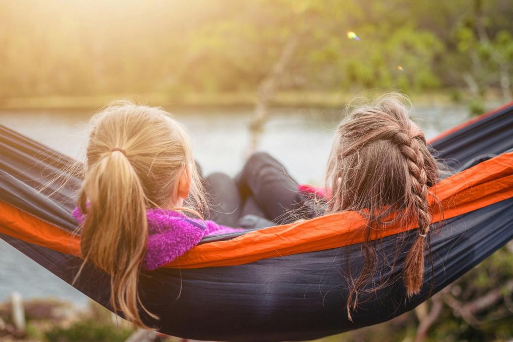 Zwei Mädchen sitzen nebeneinander in der Hängematte
