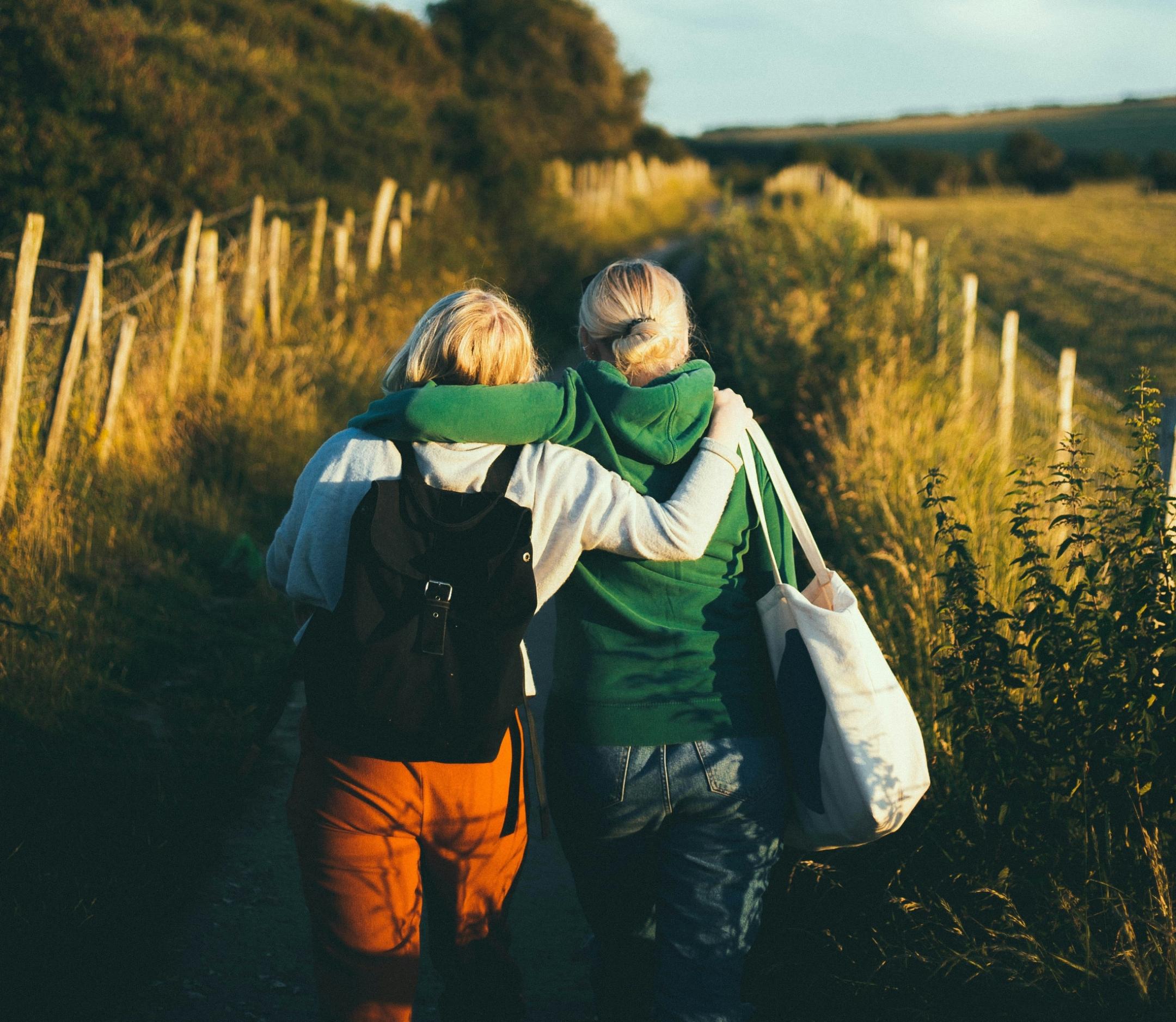 Zwei Freunde gehen umarmt einen Weg