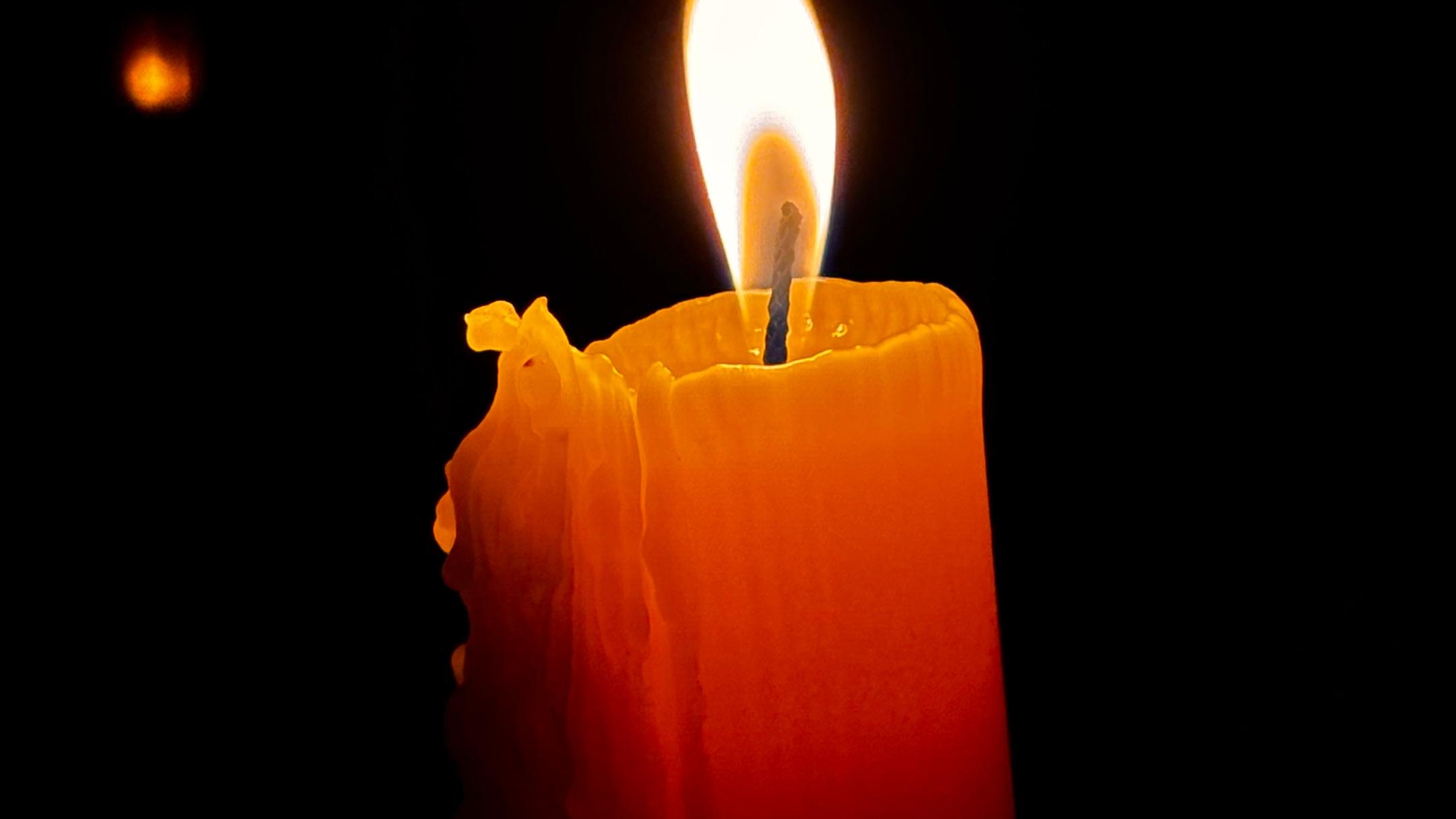 Eine Kerze brennt im Dunkeln