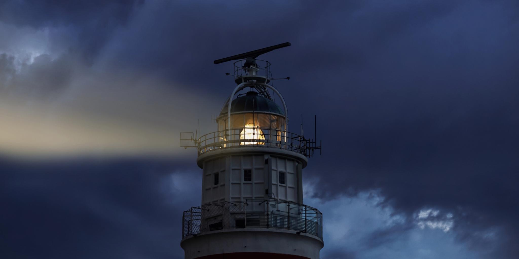 Ein Leuchtturm leuchtet in die Dunkelheit