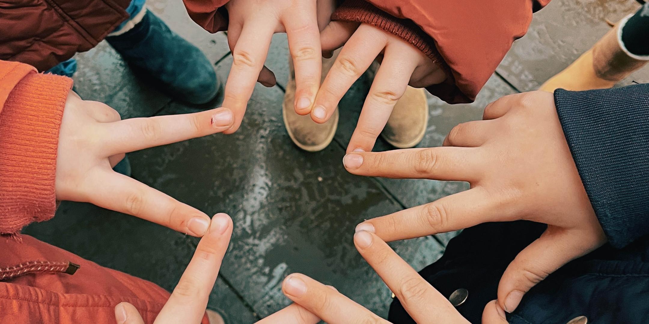 zwei Finger von sechs Händen verbinden sich zu einem Stern