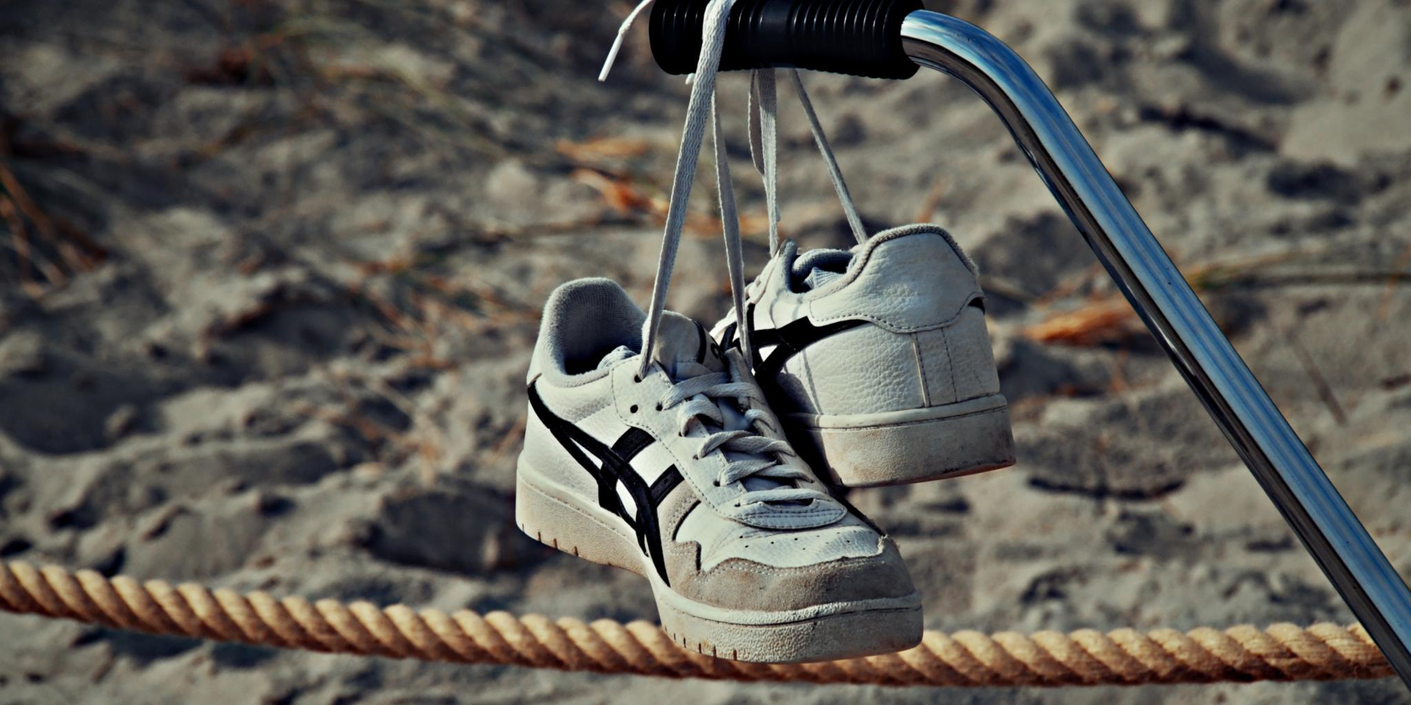 Schuhe hängen vor einem Strand