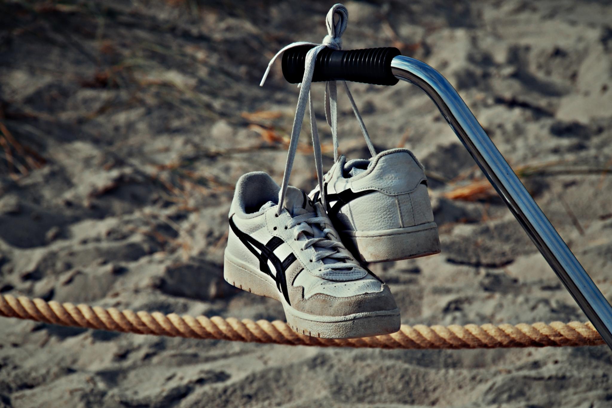 Schuhe hängen vor einem Strand