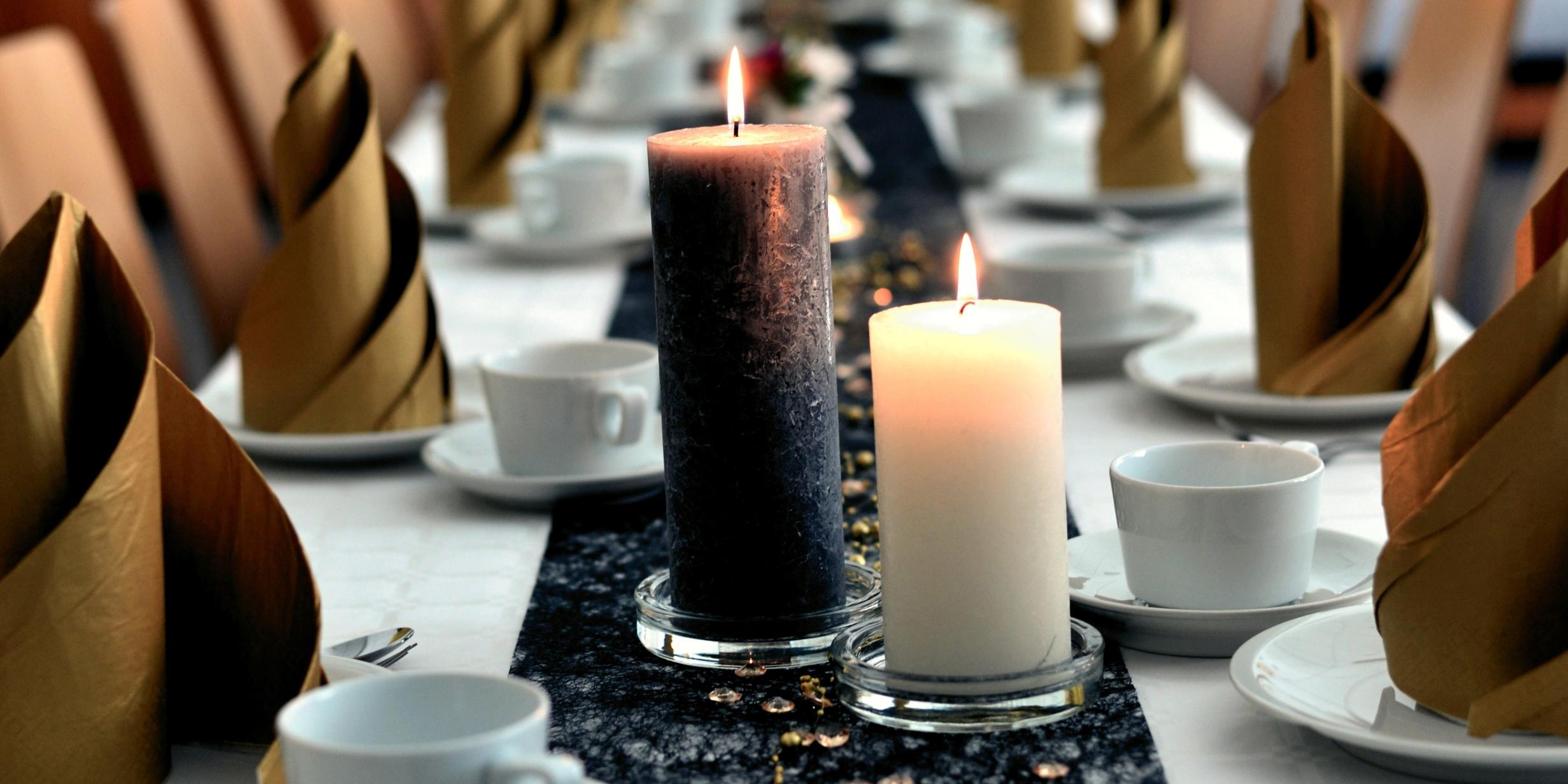 festlich gedeckter Tisch mit Kerzen, Kaffeeservice und Servietten