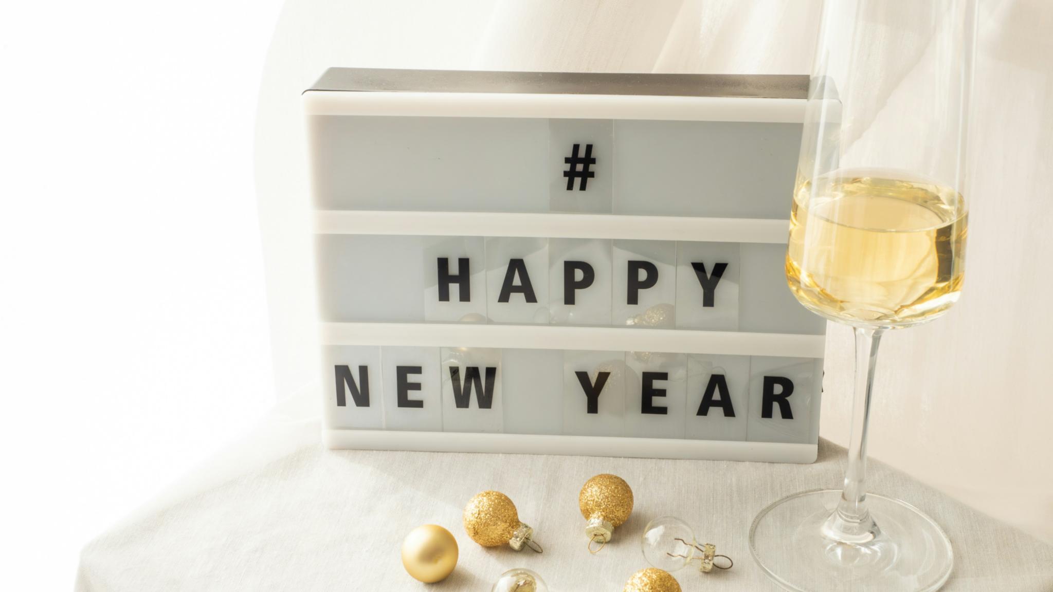 Ein Tisch mit einem Sektglas und der Auzffschrift  '' Happy New Year'