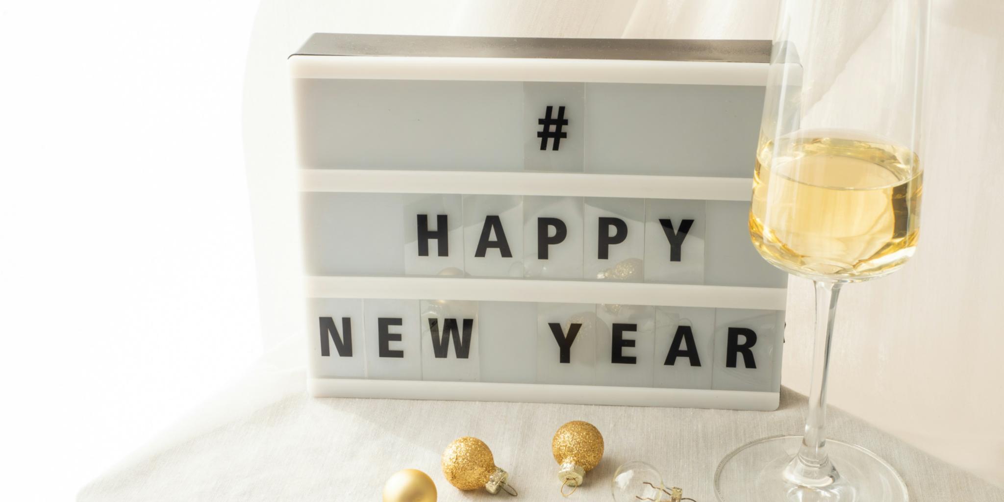 Ein Tisch mit einem Sektglas und der Auzffschrift  '' Happy New Year'